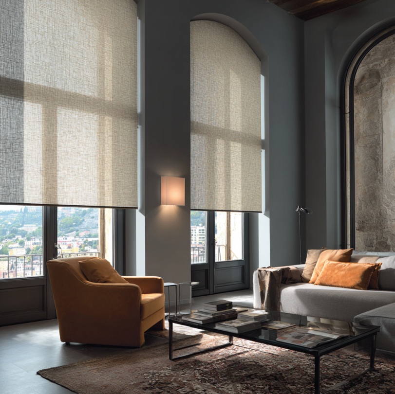 Roller shades custom-fitted into arched windows, filtering sunlight while maintaining privacy.