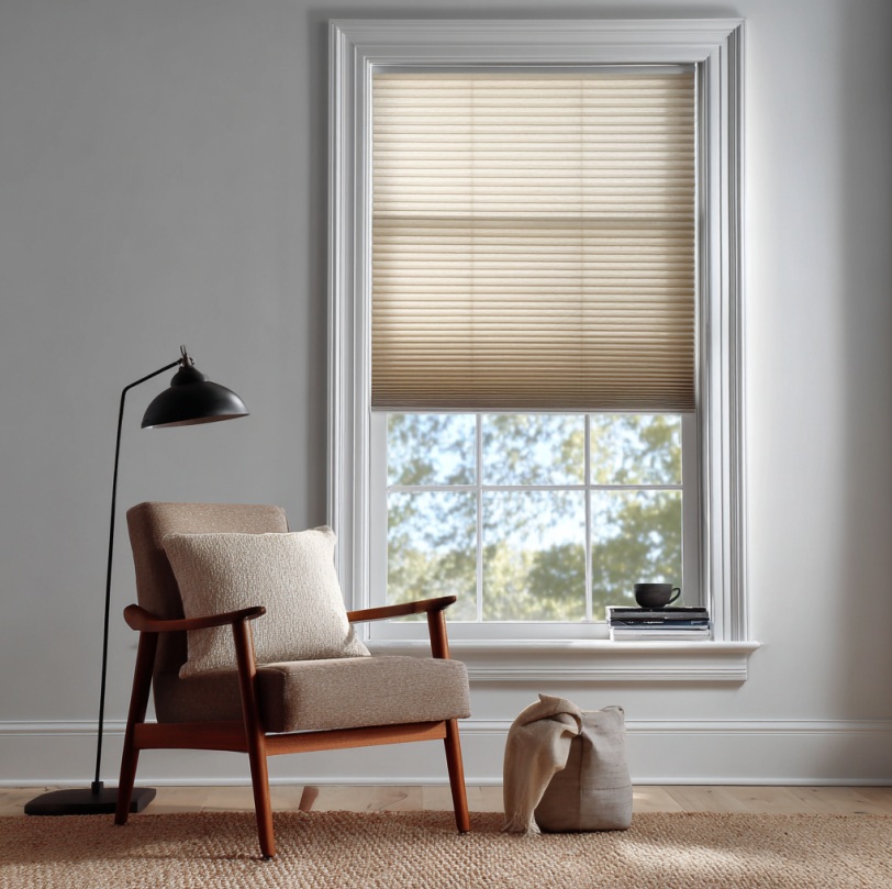 Window with cellular shade diffusing light beside a chair in a Yorba Linda, CA home.