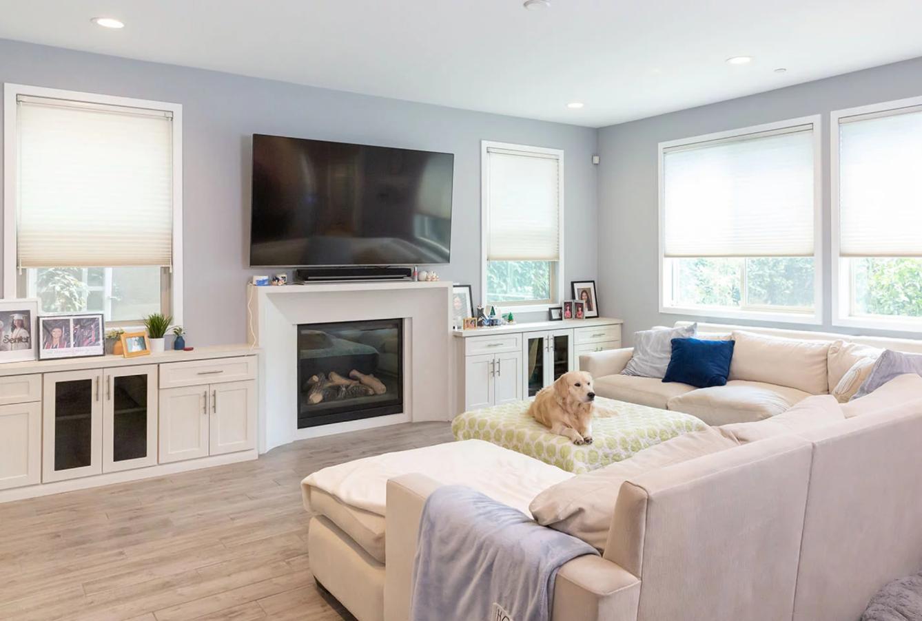 Modern living room with multiple windows fitted with light-filtering shades, highlighting custom window blinds, shades, and shutters Fullerton, CA homeowners trust for comfort and style.