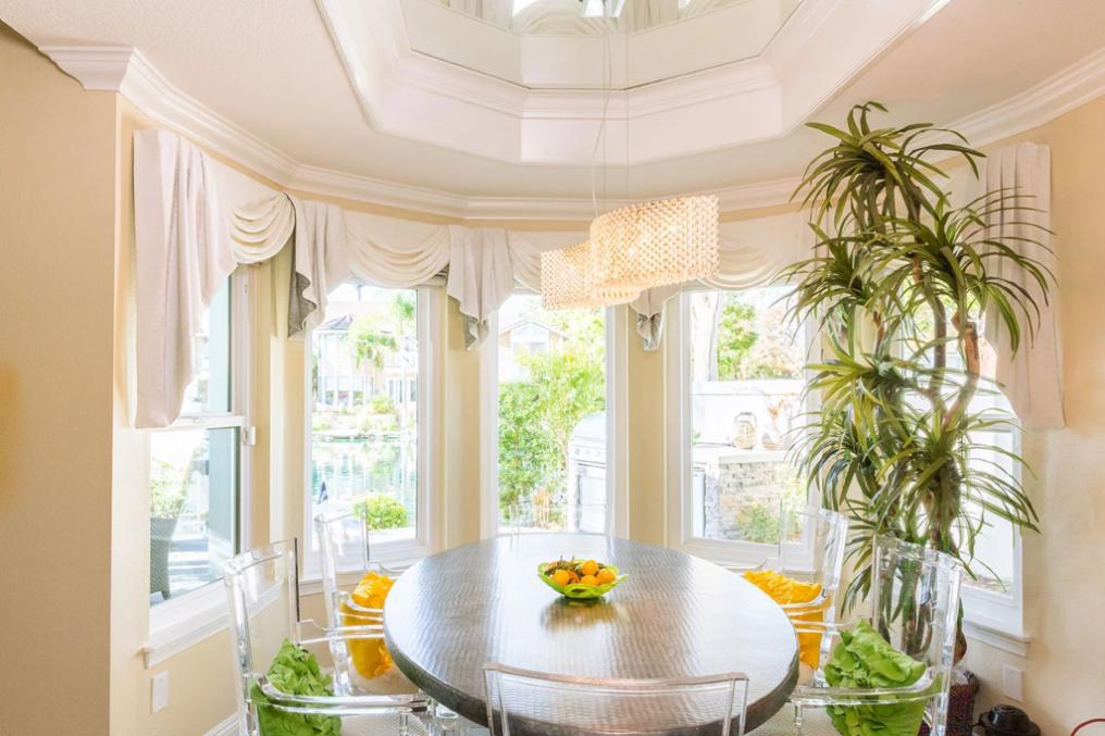 Bright dining nook with large bay windows dressed in elegant drapery, highlighting custom window blinds, shades, and shutters Placentia, CA homeowners choose for style and natural light control.