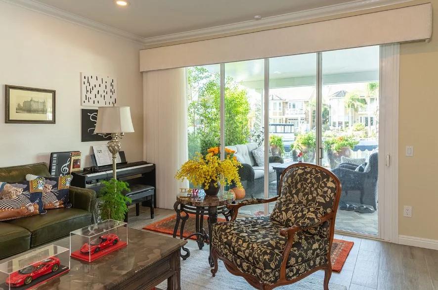 Living room with sliding glass doors featuring modern window blinds, shades, and shutters Placentia, CA homeowners rely on for style and light control.