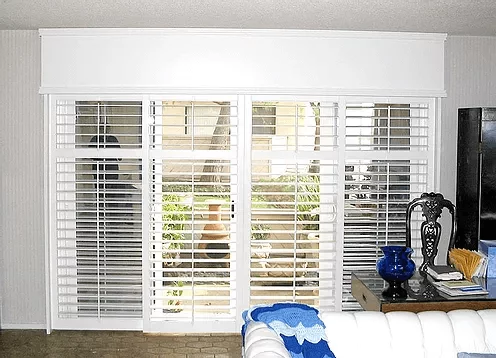 White plantation shutters on sliding doors, featuring window blinds, shades, and shutters Yorba Linda, CA.